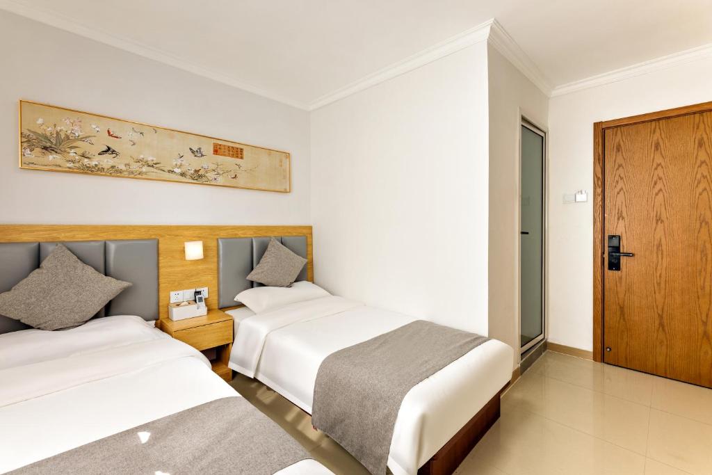 Postel nebo postele na pokoji v ubytování Happy Dragon Hotel -- Nearby Tiananmen square & Forbidden City & Wangfujing Street & Line 5,6,8 Subway Nearby & Free coffee & Free laundry & Fluent English speaking & Tourist attractions ticket service & Free WiFi unlimited for Western software
