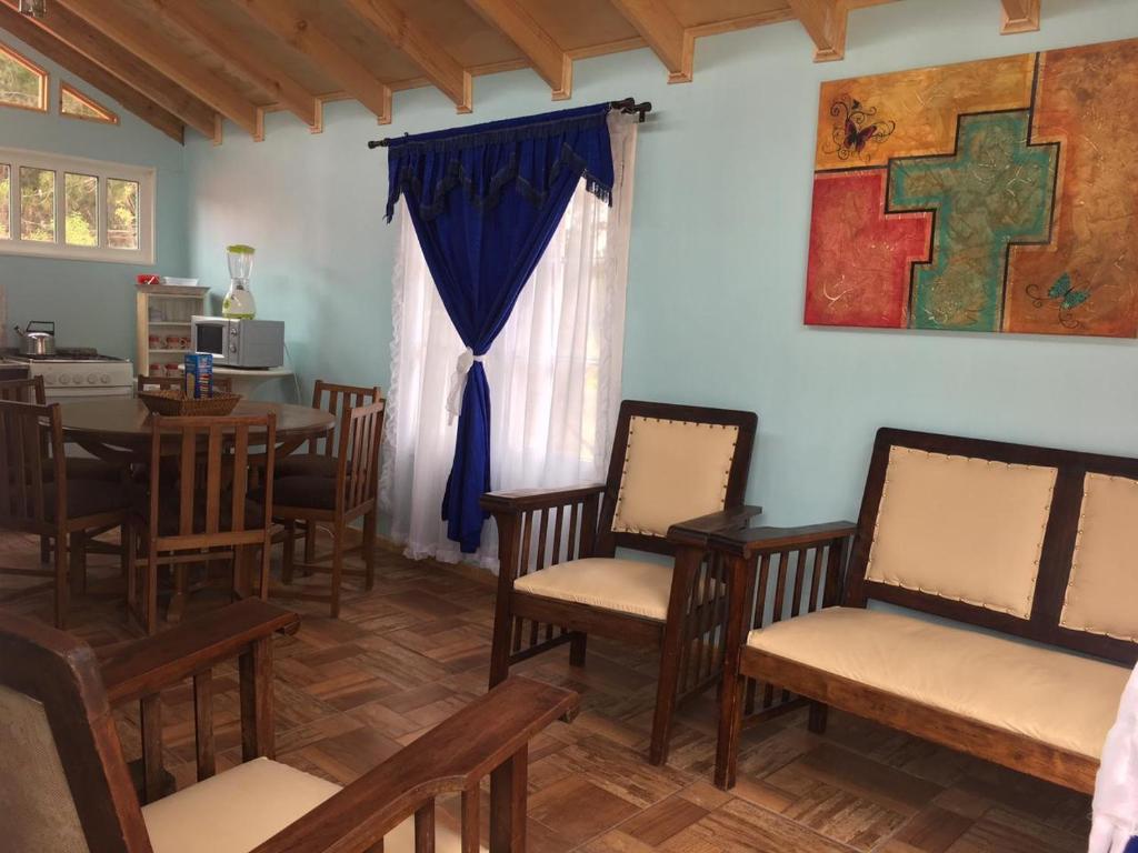 a dining room with chairs and a table and a window at Cabañas Ocean Forest in El Tabo