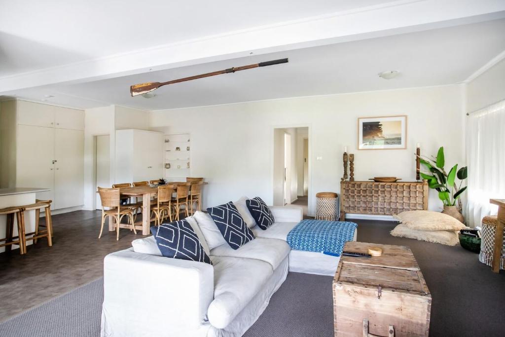 Una sala de estar con un sofá blanco y una mesa. en Pacifica, en Mollymook