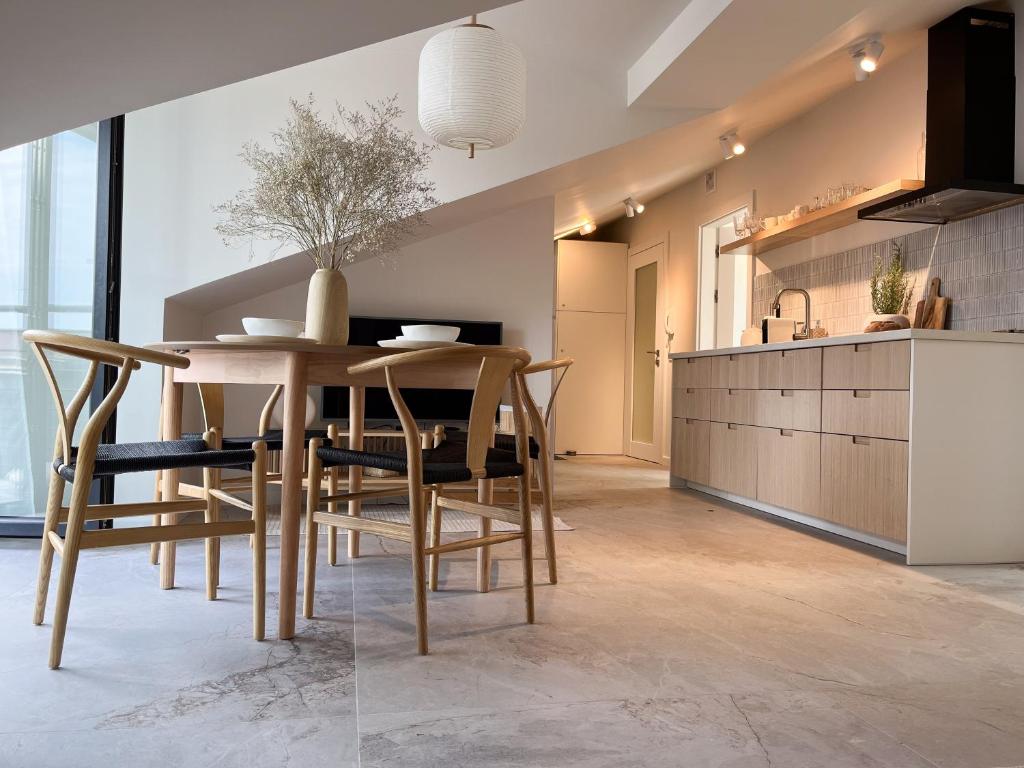 a kitchen and dining room with a table and chairs at Apartament Grossa w stylu Japandi - Dream Apart in Bielsko-Biała
