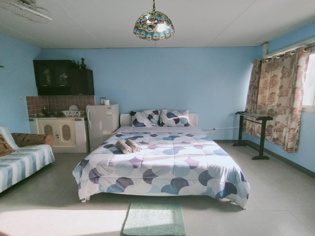 - une chambre avec un lit et un mur bleu dans l'établissement Popular C3-C9 Impact, à Nonthaburi