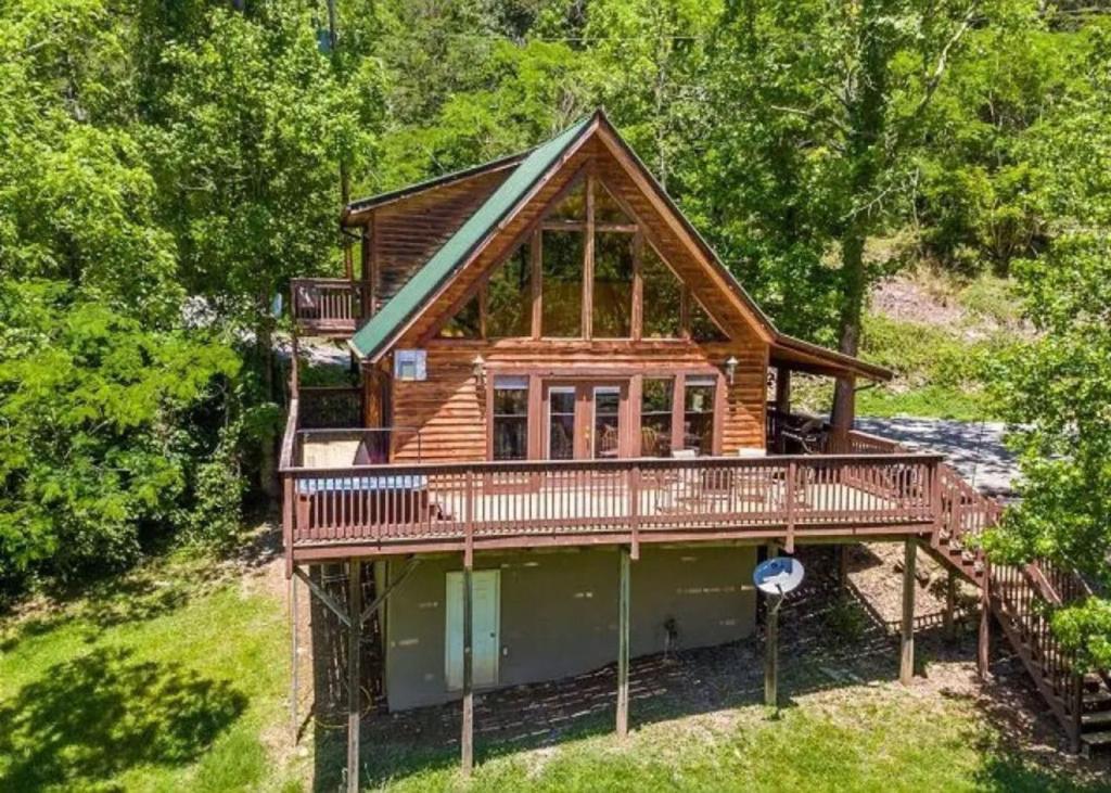 a cabin in the woods with a large deck at Smoky Waters Chalet in Sevierville