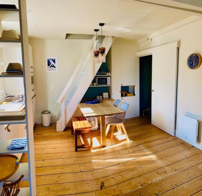 un salon avec une table et un escalier dans l'établissement Duplex plage, à Trouville-sur-Mer