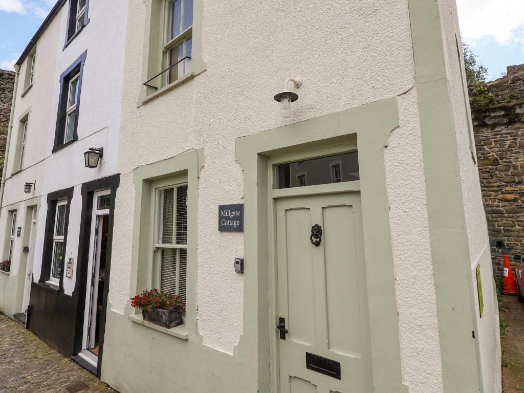 un bâtiment blanc avec une porte dans une rue dans l'établissement Millgate Cottage, à Conwy