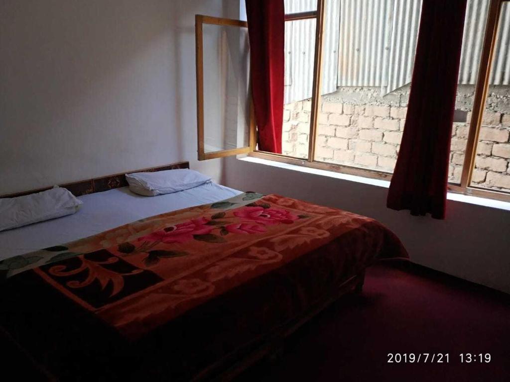 Cama en habitación con ventana en OYO Holidayinn en Kargil
