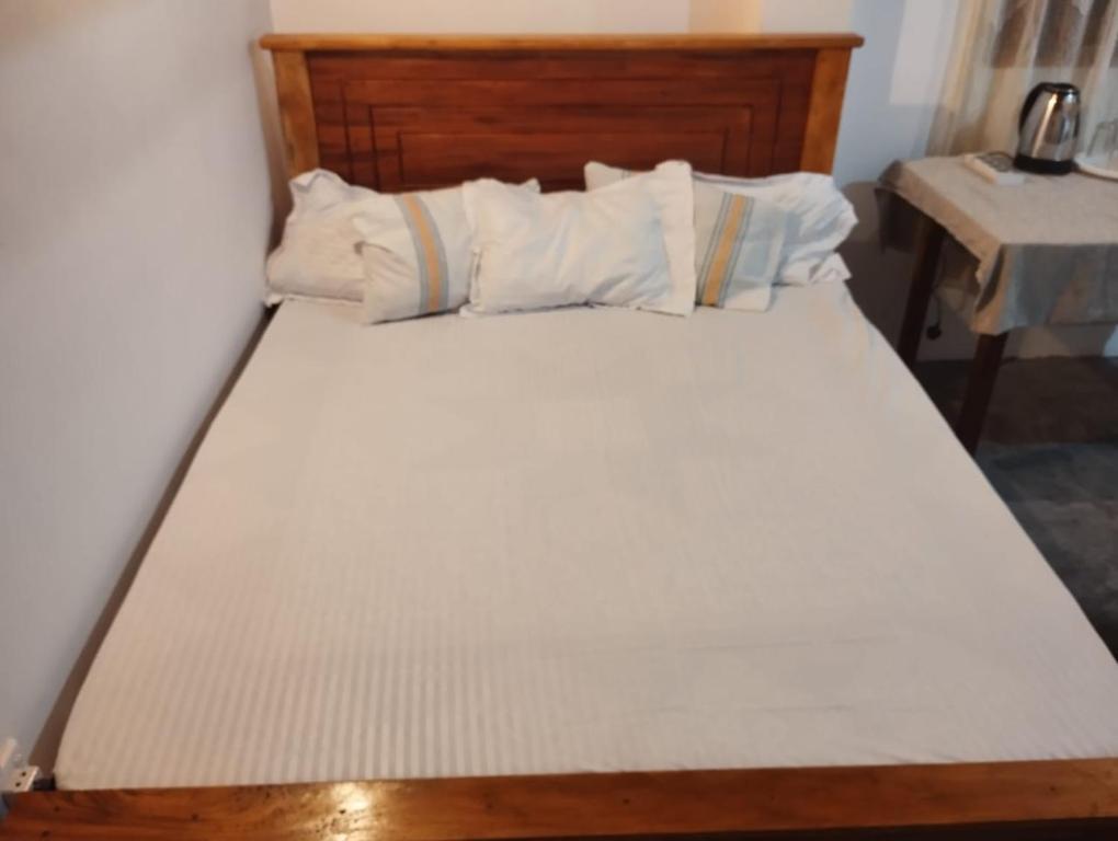 Kalawana的住宿－Sunil's Homestay Sinharaja，一张带白色床单和枕头的床