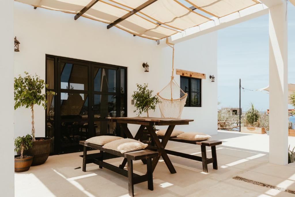 a patio with a wooden table and benches at Casa De Surfos Cerritos’s Beach in San Carlos