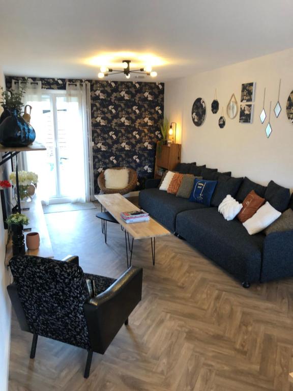 uma sala de estar com um sofá e uma mesa em Maison familiale 100m2 em Witry-lès-Reims