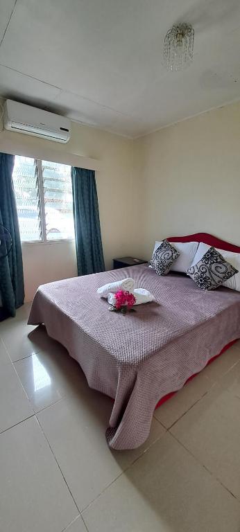 een slaapkamer met een bed met bloemen erop bij ABM Court Apartments in Nadi