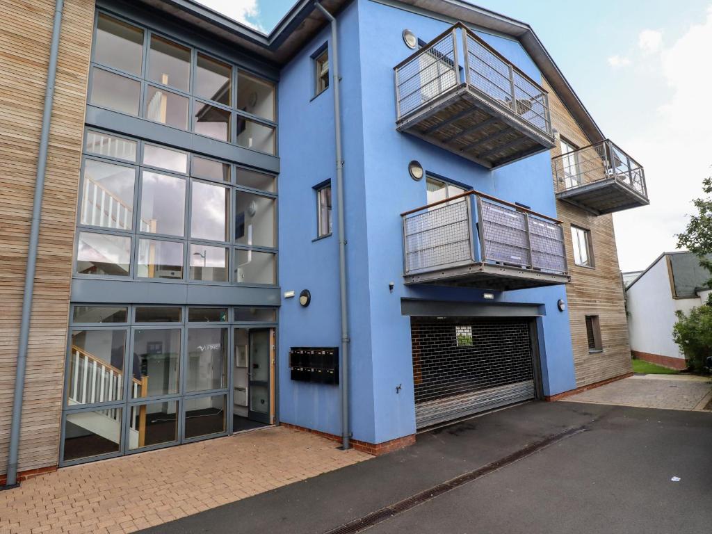 Un edificio azul con dos balcones y un garaje. en Cuddy's Holm, en Seahouses