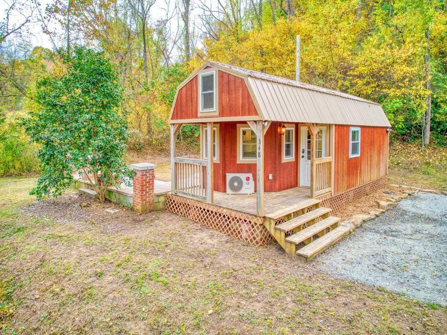 une petite maison rouge avec un escalier dans une cour dans l'établissement Casey Paradise Tiny Home Mountain Retreat, à Cullowhee