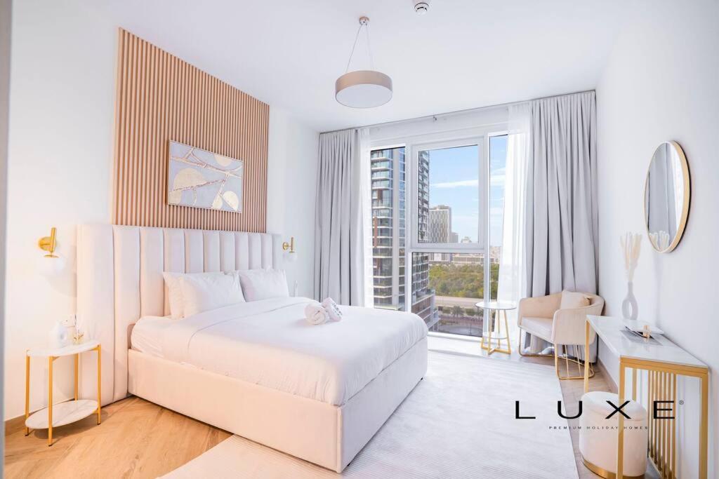 a white bedroom with a bed and a large window at LUXE- 2BR With Sofabed Nordic Haven at 1 Residences Wasl 1 in Dubai