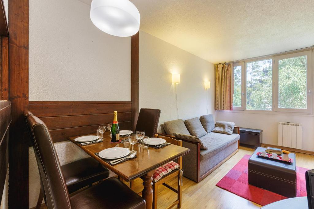 een woonkamer met een tafel en een bank bij Chamonix Sud - Chamois Blanc 110 - Happy Rentals in Chamonix-Mont-Blanc