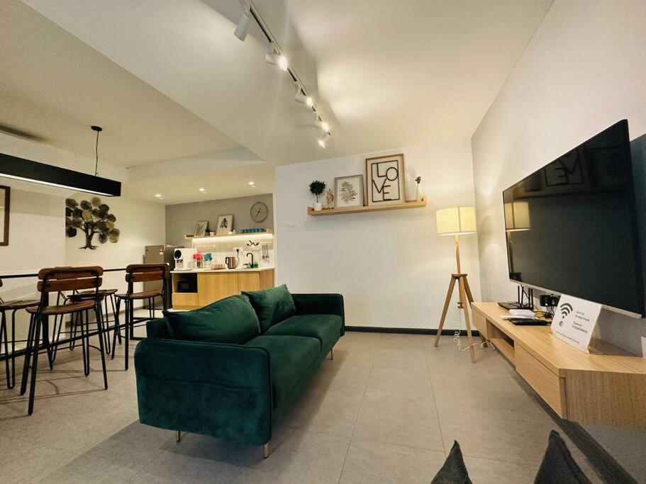 a living room with a green couch and a kitchen at New 新设计 新概念 Konzept House 2 Near Jonker@Heritage in Melaka