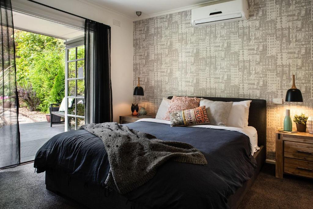 Schlafzimmer mit einem Bett und einer Glasschiebetür in der Unterkunft East Street Daylesford in Daylesford