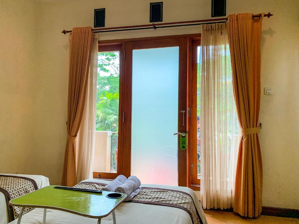 Postel nebo postele na pokoji v ubytování Urbanview Sasono Putro Condoongcatur by RedDoorz