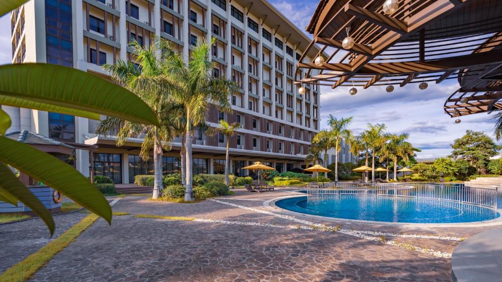 a hotel with a swimming pool in front of a building at The Bayleaf Cavite in General Trias