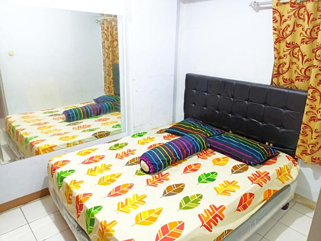 A bed or beds in a room at Apartemen cibubur village booking by hans property