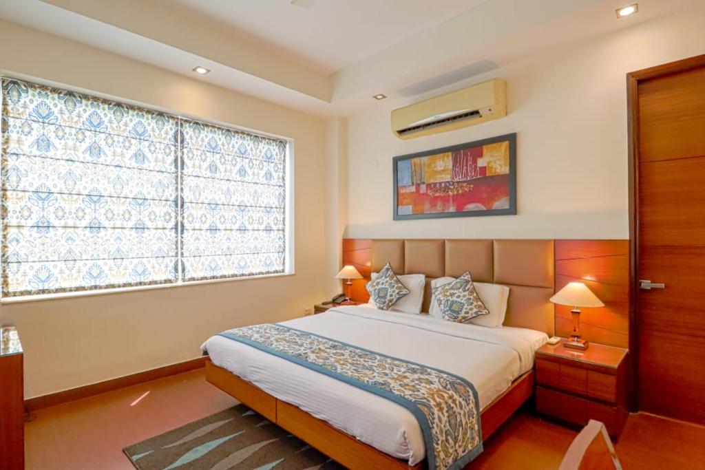 1 dormitorio con cama y ventana grande en Ahuja Residency Noida, en Noida