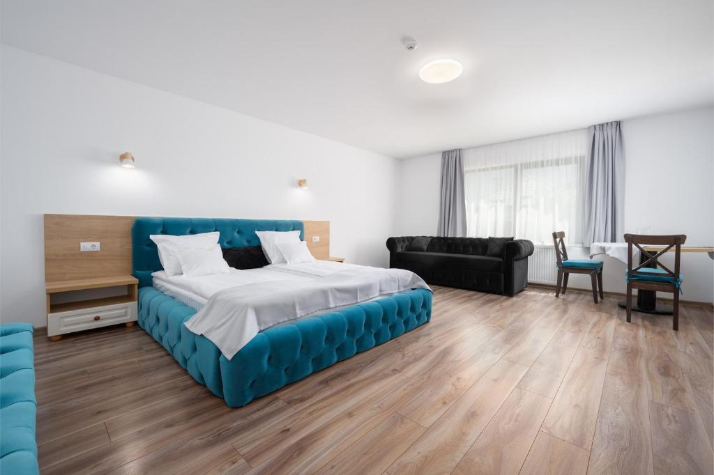 una camera con letto blu e un soggiorno di Ellys Residence a Voroneţ