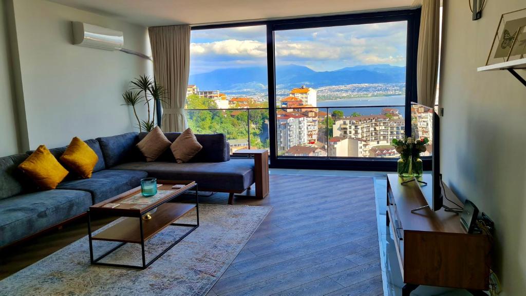 a living room with a blue couch and a large window at Amazing Sea & Mountain Duplex in Izmit in Izmit
