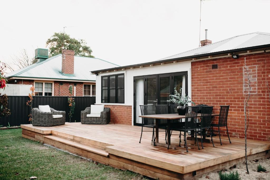 a wooden deck with a table and chairs on a house at The Settler - Boutique cottage in Dubbo