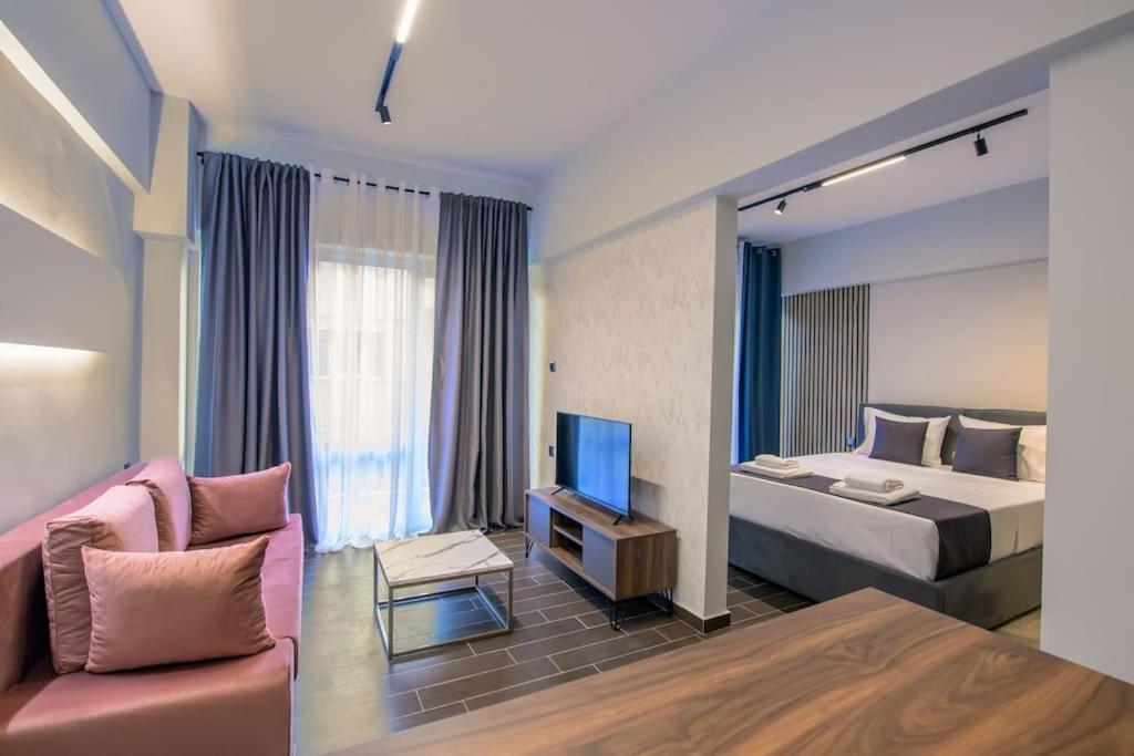 sypialnia z łóżkiem, telewizorem i kanapą w obiekcie Luxury super central apartment 1 w mieście Larisa