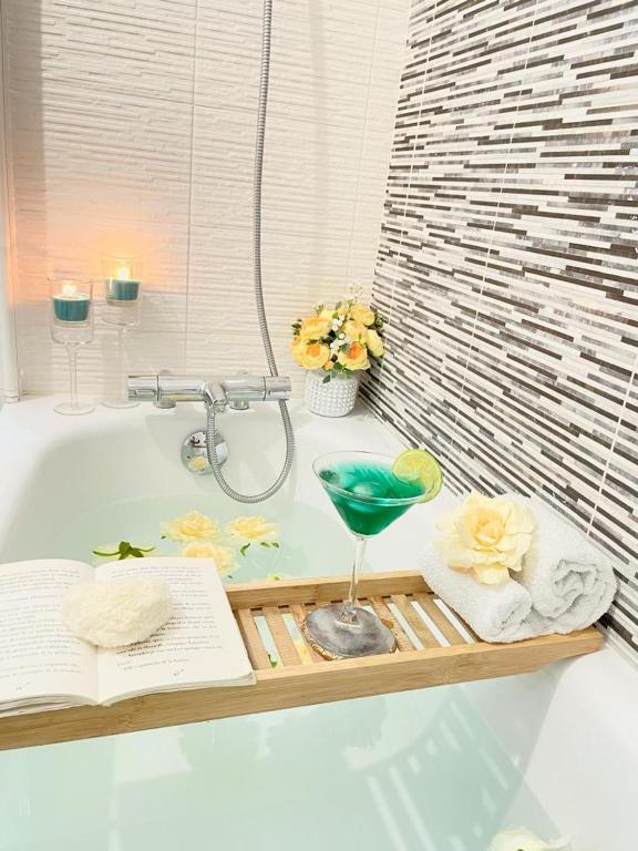 une salle de bain avec une baignoire avec un livre et des serviettes dans l'établissement Magnifique appartement 3 pièces à Vitry-sur-seine (15min de Paris), à Vitry-sur-Seine