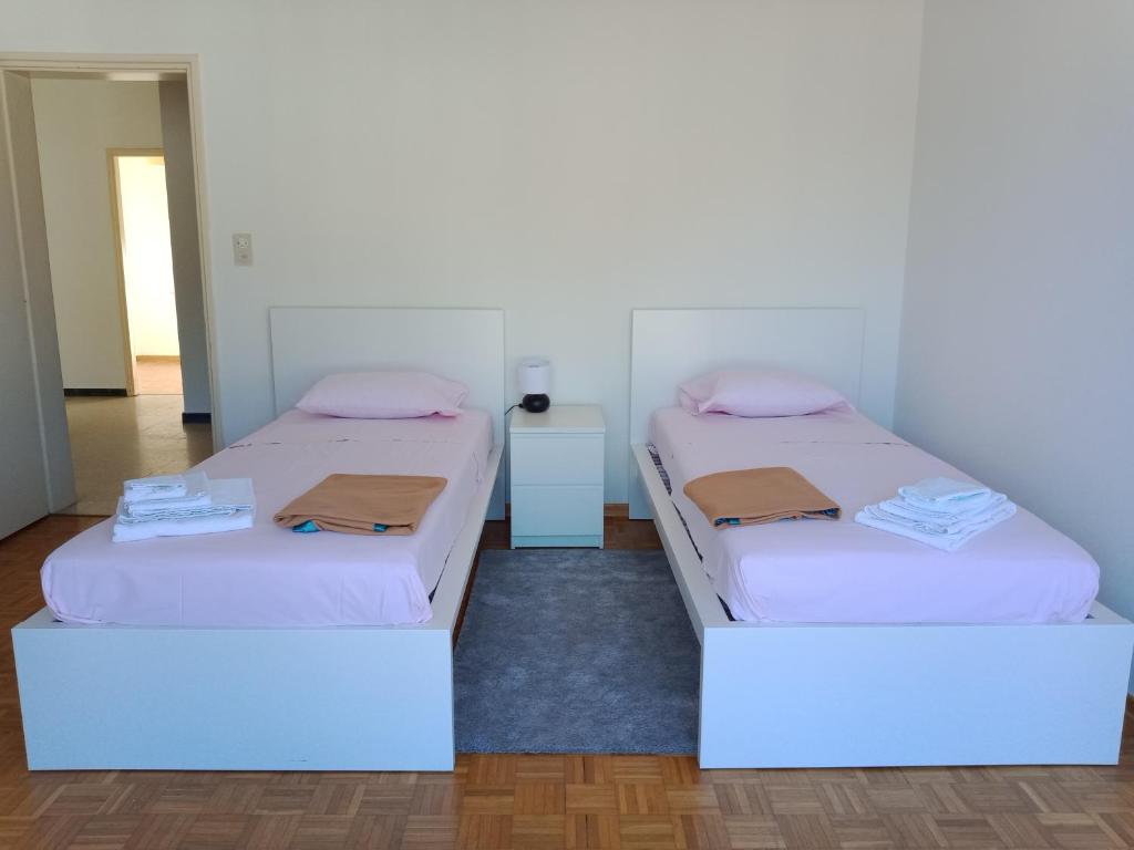 2 Betten in einem Zimmer mit weißen Wänden in der Unterkunft Cube 1B Flat in Lugano