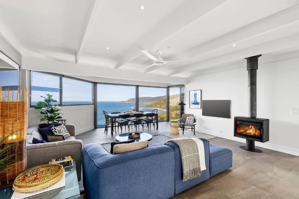 a living room with a blue couch and a fireplace at The Headland Retreat in Wye River