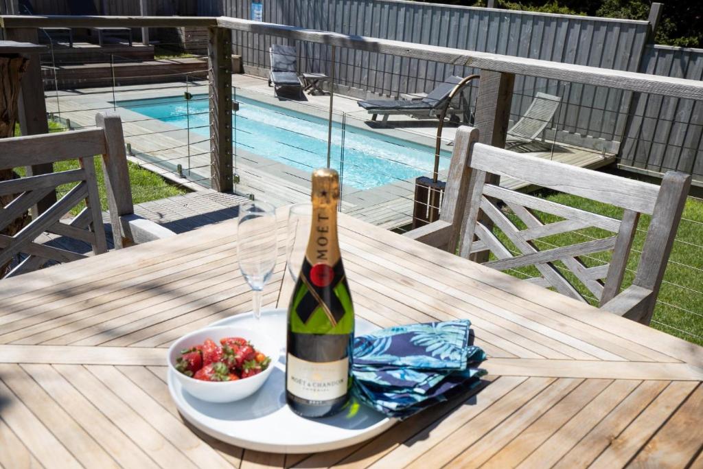 una botella de vino y un bol de fruta en una mesa en Sorrento Beach House - Perfect spot and NEW pool, en Sorrento