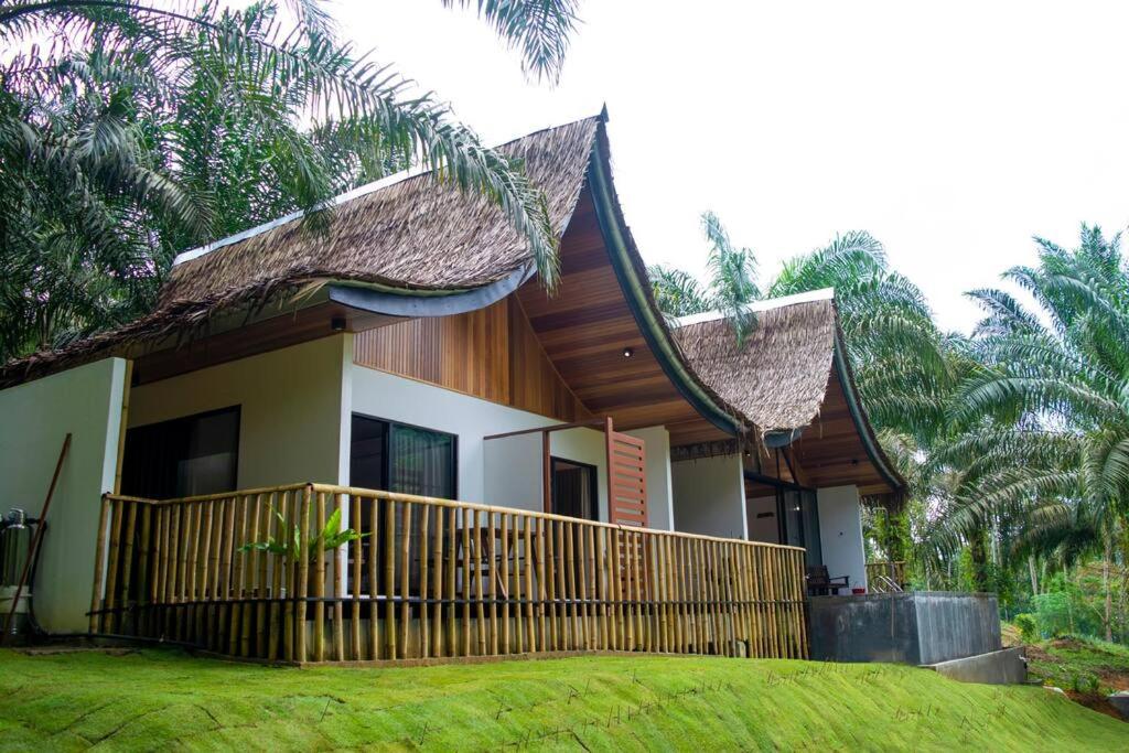 una casa con una valla delante de ella en Zen Forest Entire Villa with Private Pool at Karak, en Kampung Sunjai Gapoi