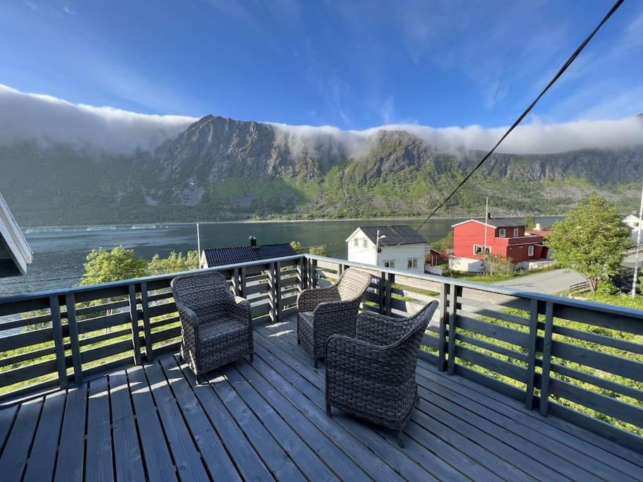 a deck with chairs and a view of a mountain at Old fisherman's house with 4 bedroom in Gryllefjord