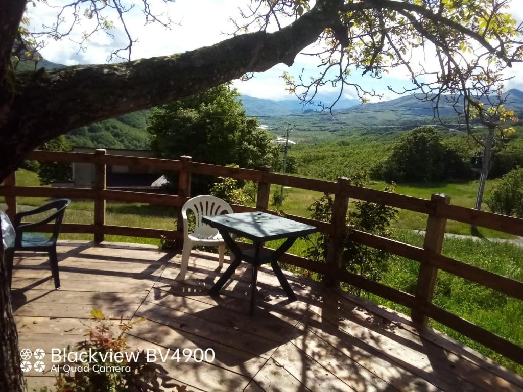 una mesa y sillas en una terraza con vistas a las montañas en Segarati Relax La Romantica, en Rocca di Varsi