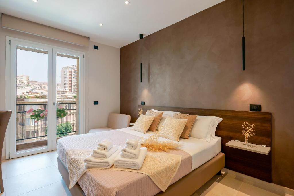 een slaapkamer met een groot bed en een groot raam bij Welcome Cagliari in Cagliari