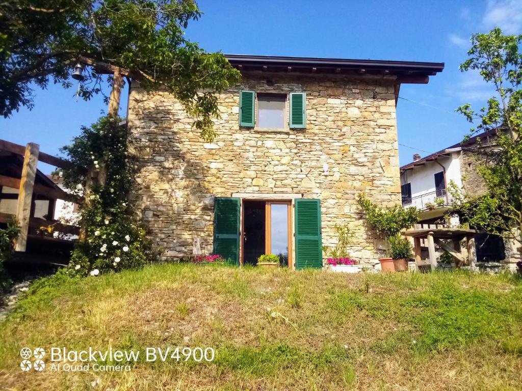 an old stone house with green shutters at Segarati Relax La Maiolica in Bardi