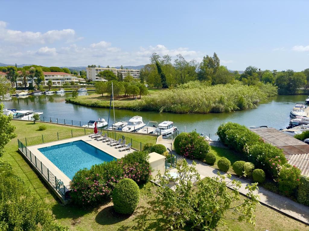 uma piscina ao lado de um rio com barcos em Magnifique 4 pièces avec Terrasse, Piscine em Mandelieu-la-Napoule