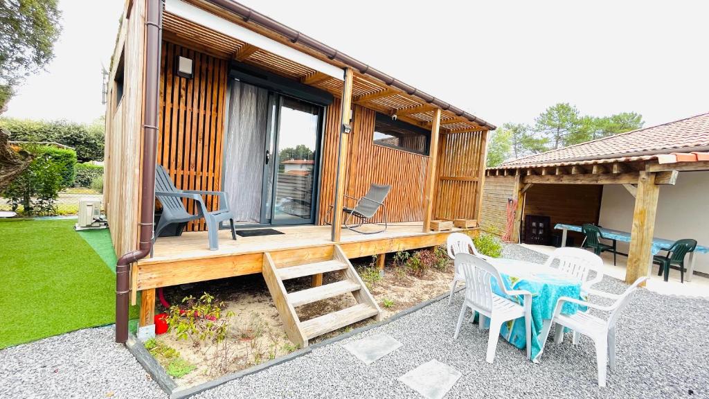 a house with a table and chairs on a patio at EcoKub T3 Proche plages Lacs in Soustons
