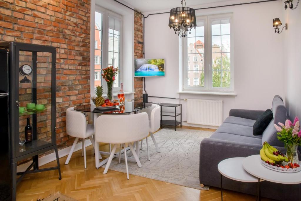 ein Wohnzimmer mit einem Sofa und einem Tisch in der Unterkunft Maya's Flats & Resorts 63 - 3 rooms flat in old town Gdansk in Danzig