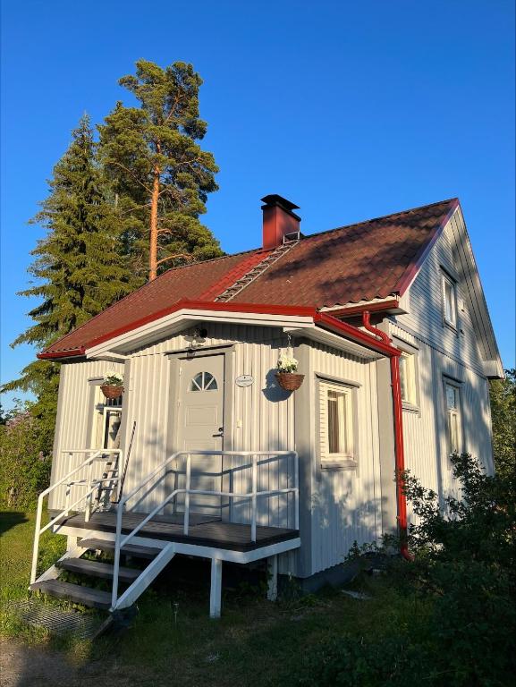 a small white house with a porch and a tree at Villa Taivaanvuohi in Kyrö