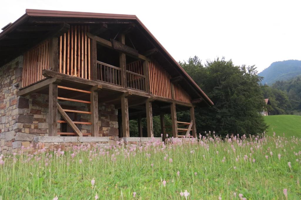 a large wooden building in a field of grass at Baita Misonet in Comano Terme
