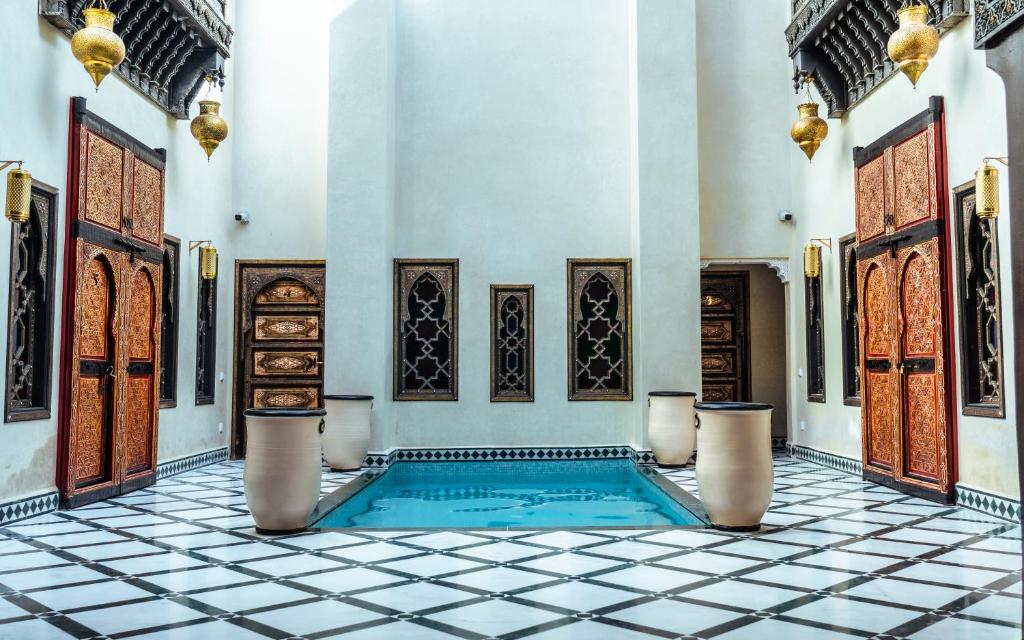 a swimming pool in a room with a tiled floor at Riad Deluxe in Marrakech