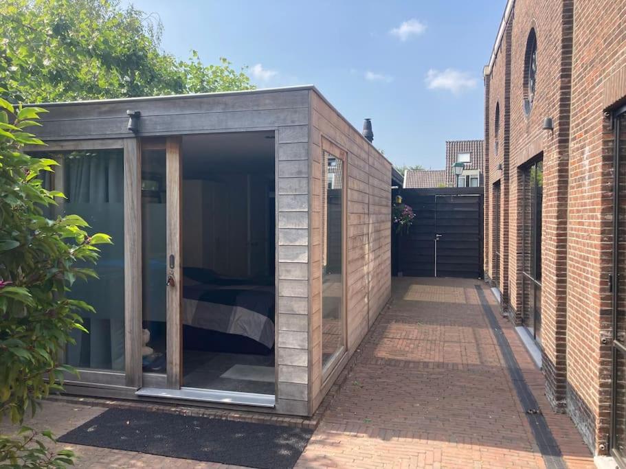 a small black shed in a courtyard between two buildings at Tuinhuis aan het water in Voorburg