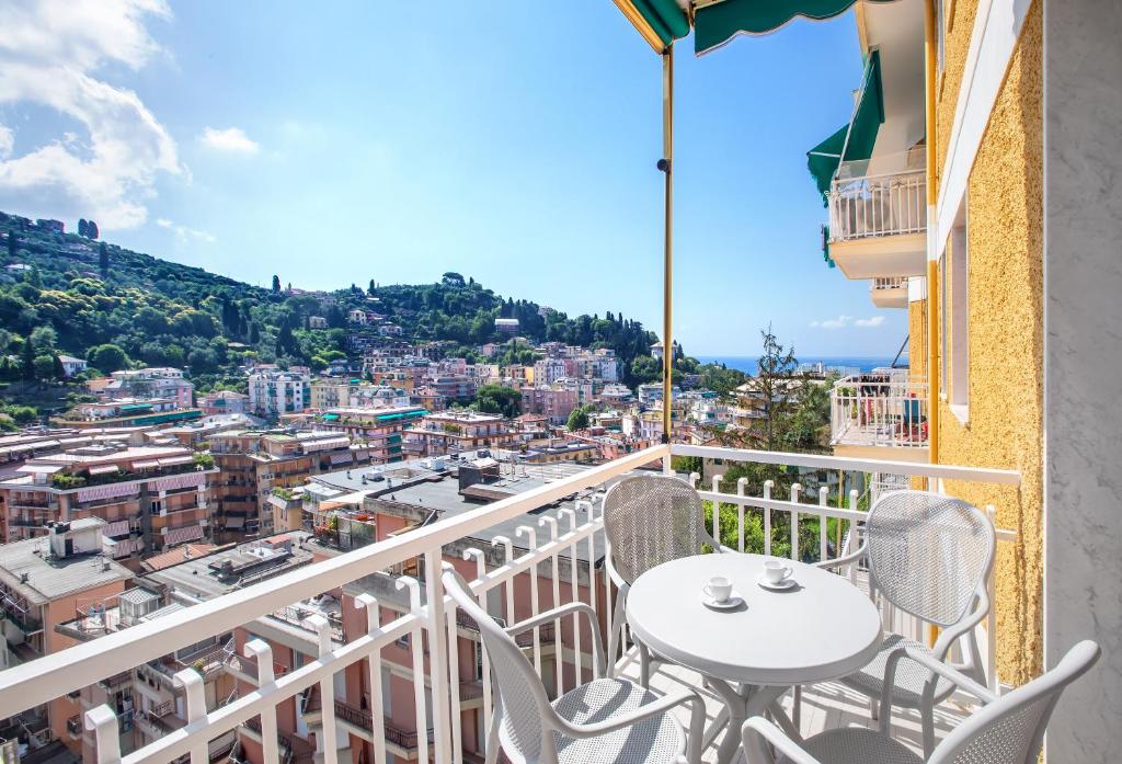 a balcony with a table and chairs overlooking a city at Dipinto di Blu by PortofinoVacanze in Rapallo