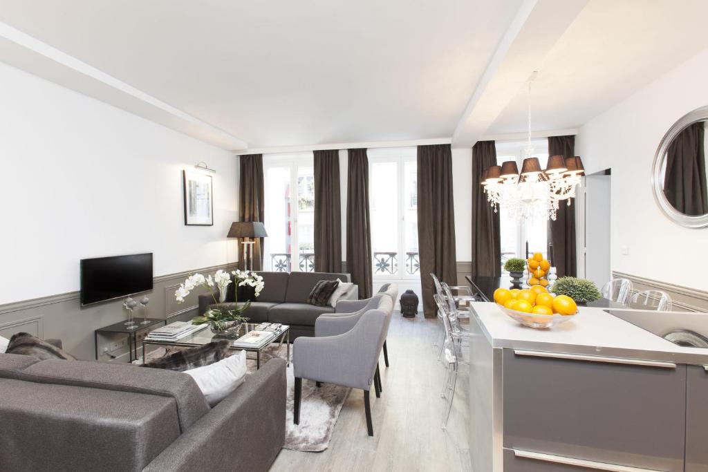un salon avec un canapé et une table dans l'établissement LivinParis - Luxury 3 Bedrooms Grands-Boulevards I, à Paris