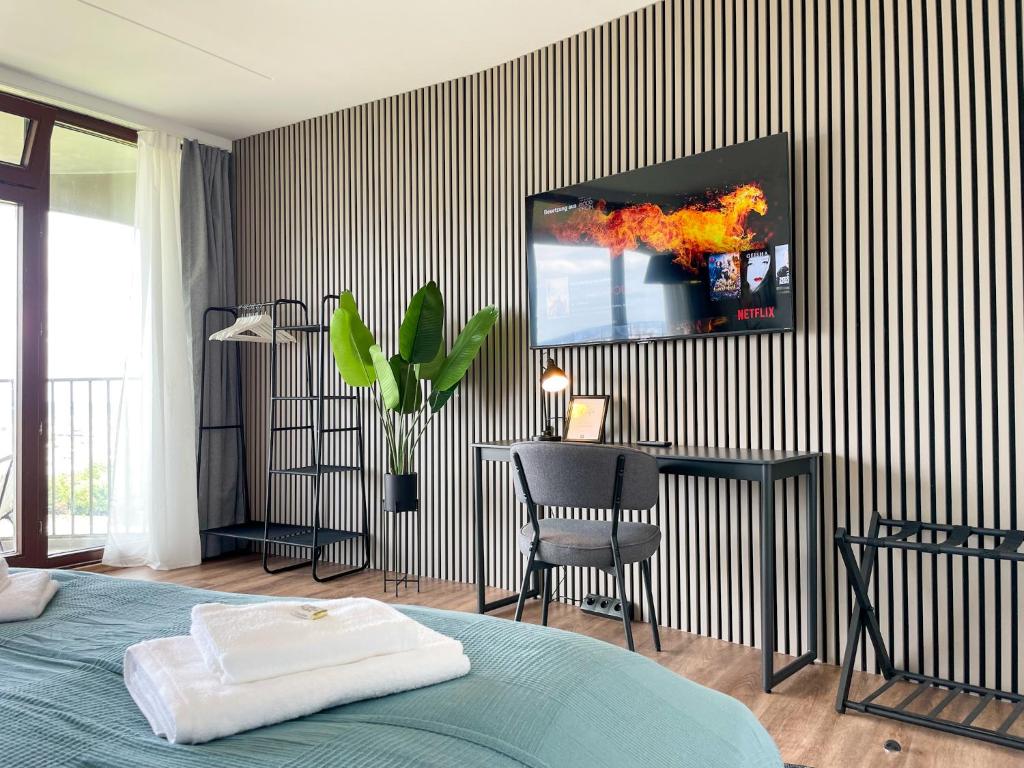 a bedroom with a tv on a striped wall at E&K living - NEU - 23.OG - Stadtblick - Kongress in Augsburg