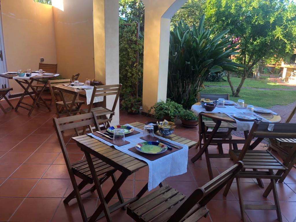 a patio with tables and chairs with food on them at West Coast in Càbras