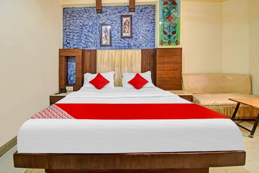 sypialnia z dużym łóżkiem z czerwonymi poduszkami w obiekcie Flagship S S G Residency w mieście Mysuru