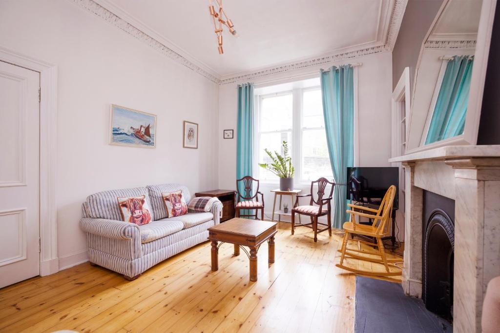 a living room with a couch and a fireplace at ALTIDO Splendid 2bed apt near Haymarket in Edinburgh