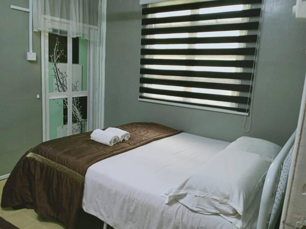 Tumpat的住宿－Homestay Murah Orkid，一间卧室配有一张床,上面有两条毛巾